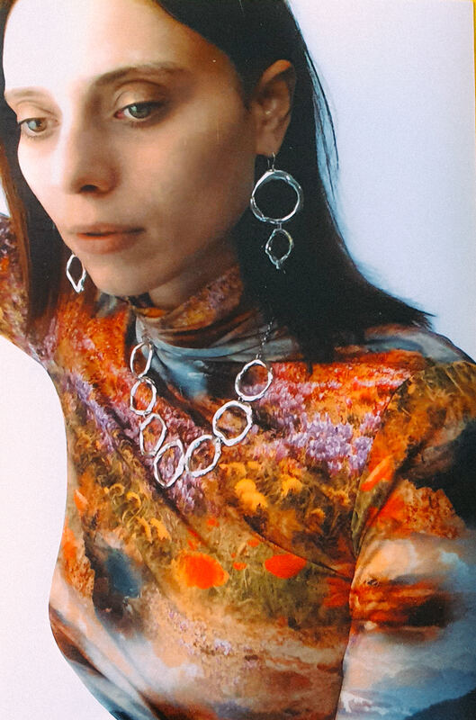 Long cell earrings and a cell necklace over a painted top