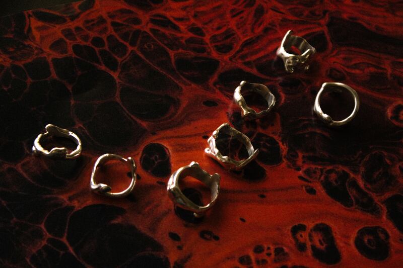 Sculpted silver studs on a red, molten-looking surface