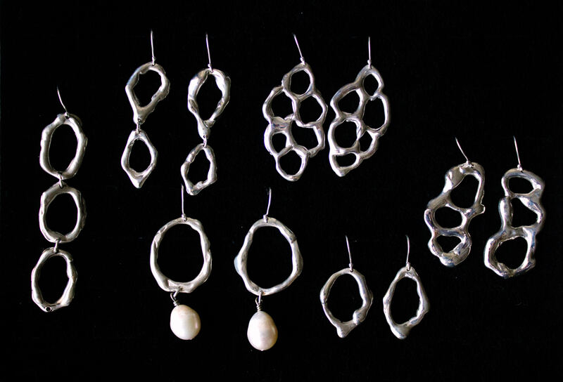 Earrings from the collection laid out on black, some with pearl drops