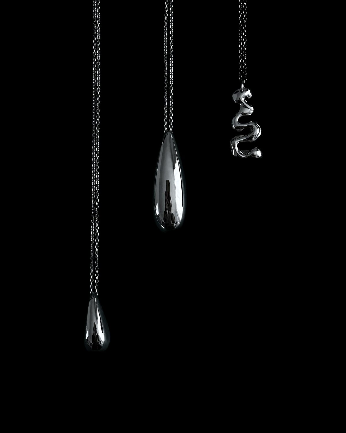 Three pendants side by side: the large and small Larme drops and the Onde ribbon